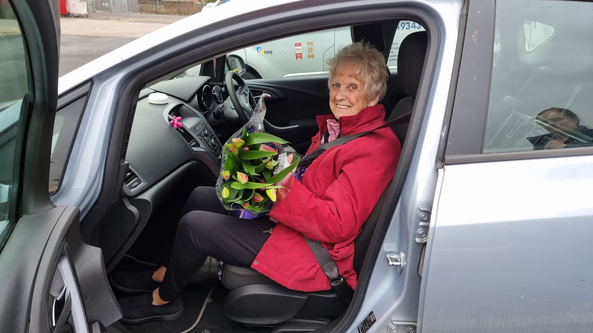 Ableworld Runcorn customer getting into her car with flowers from staff